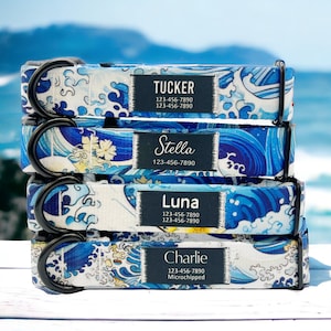 May include: Four dog collars stacked on top of each other. The collars are blue and white with a wave pattern and have black metal D-rings. Each collar has a black label with white text that includes a dog's name, phone number, and microchip information. The names on the collars are Tucker, Stella, Luna, and Charlie.