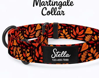 May include: Martingale dog collar with a black background and a pattern of orange and yellow leaves. The collar has a black metal ring and a black name tag that says "Stella" and a phone number.