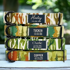 May include: Four colourful dog collars with black metal D-rings and personalised name tags. The collars feature a woodland camouflage pattern with trees, branches, and leaves. The name tags include the names "Harley", "Tucker", "Charlie", and "Copper" with phone numbers and "Microchipped" text.