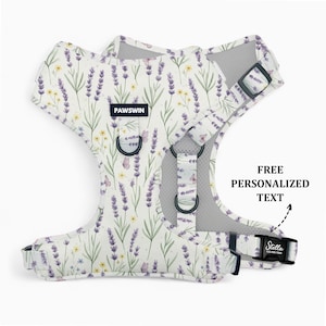May include: A dog harness featuring a floral design of lavender and yellow flowers on a white background. It has black metal rings and buckles. The text "PAWSWIN" is printed on the front. The text "FREE PERSONALIZED TEXT" is also visible.