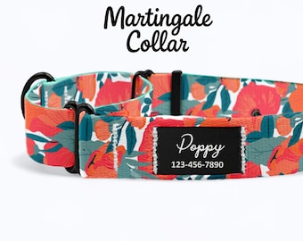 May include: A floral martingale dog collar with a teal and white background and red and orange flowers. The collar has a black metal clasp and a black label with the name "Poppy" and a phone number.