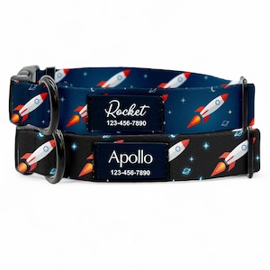 May include: Two dog collars featuring a rocket ship design. One is navy blue with white rockets, the other black with white rockets. Each collar has a name tag with a name and phone number.