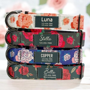 May include: Four dog collars with floral patterns and personalised name tags. The collars are stacked on top of each other. The top collar is white with pink roses and the name "Luna" on the tag. The second collar is black with red roses and the name "Stella" on the tag. The third collar is blue with white roses and the name "Copper" on the tag. The bottom collar is black with red roses and the name "Bella" on the tag.