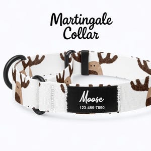 Könnte beinhalten: Weißes Martingale-Halsband mit einem sich wiederholenden Muster aus braunen Elchkopf-Motiven. Das Halsband hat schwarze Beschläge und ein schwarzes Etikett mit "Moose" und einer Telefonnummer. Die Worte "Martingale Collar" sind in schwarzer Schrift geschrieben.
