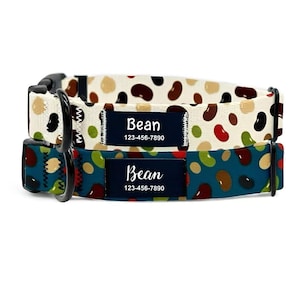 May include: Two dog collars with bean patterns. One collar has a cream background with brown, black, and red beans. The other has a teal background with green, brown, and red beans. Each collar has a black buckle and a navy blue name tag that says "Bean" and a phone number.