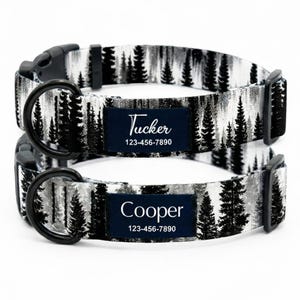 Puede incluir: Dos collares para perros con un estampado de bosque en blanco y negro. Cada collar tiene una etiqueta con el nombre en azul marino con un nombre y un número de teléfono impresos en blanco. Una etiqueta dice "Tucker" y la otra "Cooper".