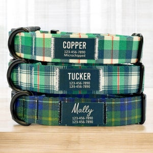 May include: Three dog collars in a green, white and red tartan pattern with black metal buckles. Each collar has a black rectangular tag with white text. The top tag reads "COPPER 123-456-7890 Microchipped". The middle tag reads "TUCKER 123-456-7890 123-456-7890". The bottom tag reads "Mally 123-456-7890 123-456-7890".