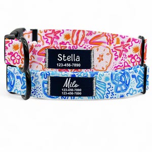 May include: Two colorful dog collars with black buckles and personalized name tags. The top collar is pink with orange and white accents and says "Stella 123-456-7890". The bottom collar is blue with white and orange accents and says "Milo 123-456-7890 123-456-7890".