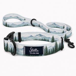 May include: A pet collar and matching lead set featuring a light blue and green mountain and pine forest landscape print. The collar includes a black plastic buckle, a black metal D-ring, and a dark rectangular tag with the text Stella 123-456-7890.