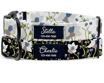 May include: Two personalized dog collars. One collar features a white background with blue and brown floral patterns, the other has a black background with white and blue floral patterns. Each collar has a navy blue name tag with a name and phone number.