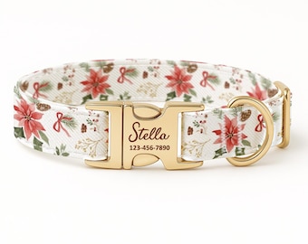 Puede incluir: Un collar blanco para perros con un estampado floral festivo con flores de Pascua rojas, hojas verdes y piñas. La hebilla dorada está grabada con el nombre "Stella" y un número de teléfono.