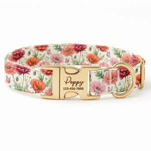 May include: A floral dog collar featuring a white background with red, pink, and orange poppy flowers. The collar has a gold-colored metal buckle with the name "Poppy" and a phone number.