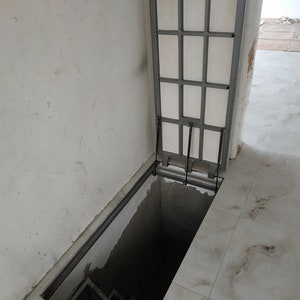 Interior hatch door to cellar basement Custom metal trapdoor Hidden utility hatchway Access panel in laminate and ceramic floor Sewer cover