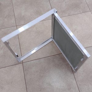 Könnte beinhalten: Eine weiße Metall-Zugangsklappe mit einer Scharniertür. Die Tür ist geöffnet und zeigt ein graues Maschengewebe.