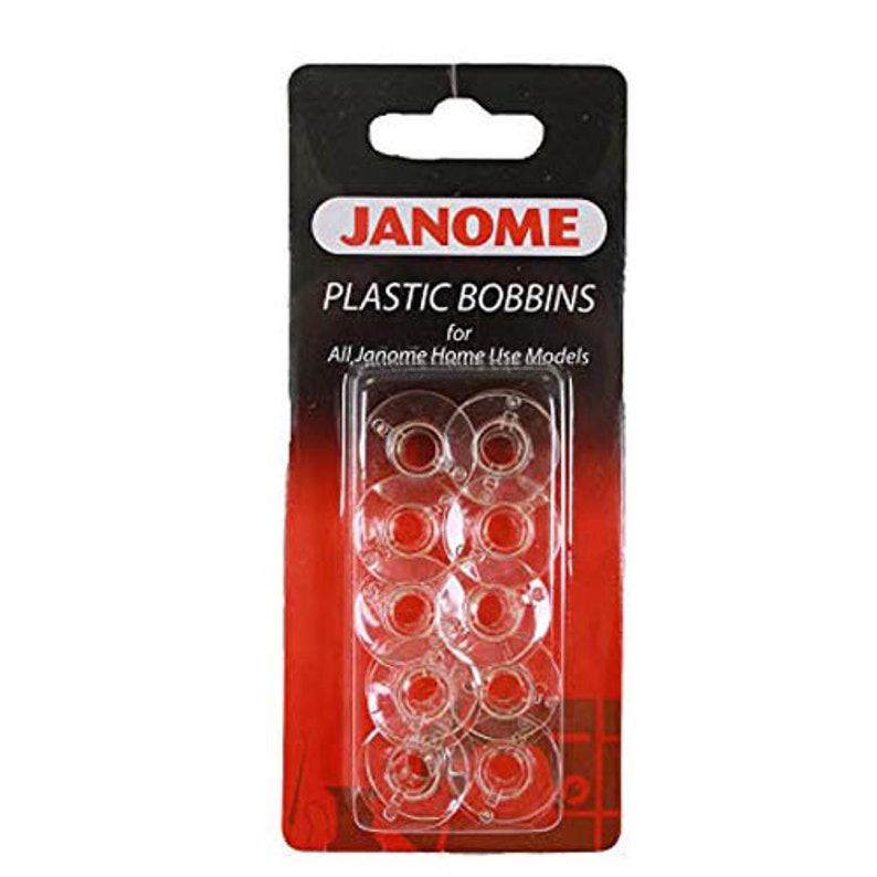 May include: A package of clear plastic bobbins for Janome sewing machines. The package has a black top with a white and red label that reads "JANOME PLASTIC BOBBINS". The bobbins are visible through a clear plastic window.