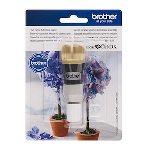 Op de afbeelding: Een Brother Thin Fabric Auto Blade Holder in een transparante plastic verpakking. De houder is beige, zwart en wit. De verpakking bevat tekst in meerdere talen, waaronder "Genuine Brother Original."