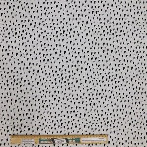 Peut inclure: Tissu blanc avec un motif de gouttes de pluie noires. Le tissu est présenté avec une règle mesurant 91,44 cm.