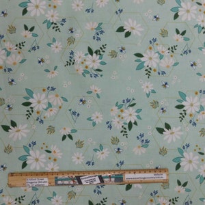 May include: White daisies and bees on a light green background with a pattern of gold hexagons. The fabric is ideal for quilting, crafts, and home decor projects.