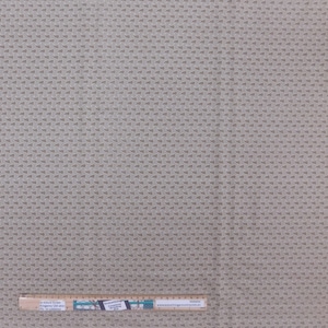 Könnte beinhalten: Ein beigefarbener Stoff mit einem sich wiederholenden Muster aus kleinen braunen Paisley-Formen. Der Stoff wird mit einem Lineal zur Skalierung gezeigt.