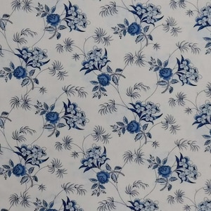 May include: White fabric with a repeating pattern of blue floral designs. The flowers are stylized and have a vintage look.