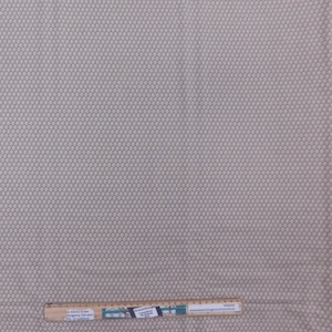 Könnte beinhalten: Nahaufnahme eines beigefarbenen Stoffes mit einem kleinen weißen Blumenmuster. Der Stoff ist strukturiert und hat einen dezenten Glanz. Der Stoff wird mit einem Lineal gemessen, auf dem "Something Country" und eine Website-Adresse stehen.