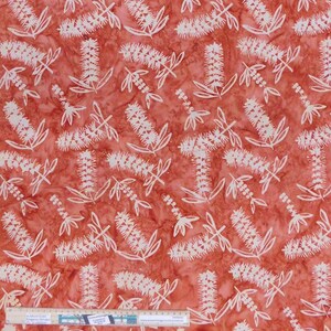 May include: Red batik fabric with a white floral pattern. The fabric features a repeating pattern of stylised flowers with long, thin petals.