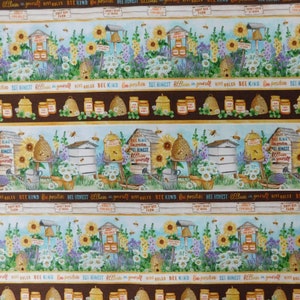 May include: Fabric with a repeating pattern of bee-themed imagery. The design includes beehives, sunflowers, jars of honey, and text that reads "Honey for Sale" and "Bee Kind." The color palette features brown, yellow, blue, and green.