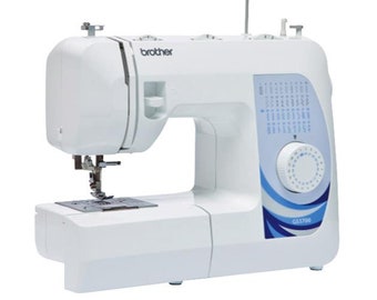 May include: A white Brother GS3700 sewing machine. The machine has a white body with blue accents and a control panel. The model name is visible on the side. The machine has a needle, presser foot, and a work surface.
