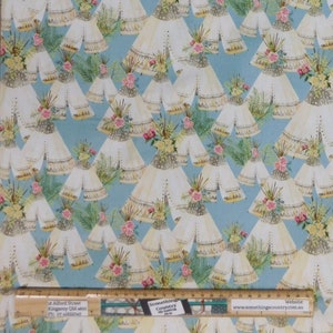 May include: A blue fabric with a repeating pattern of white teepees decorated with flowers and greenery. The fabric has a white background with a light blue pattern.