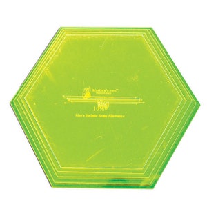May include: A green plastic hexagon-shaped quilting ruler with multiple sizes marked on it. The ruler is labelled "Matilda's own" and "Size's Include Seam Allowance".