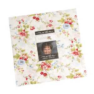 May include: A white fabric with a floral pattern featuring red, pink, and blue flowers on a white background. The fabric is labeled "moda sweet Liberty".