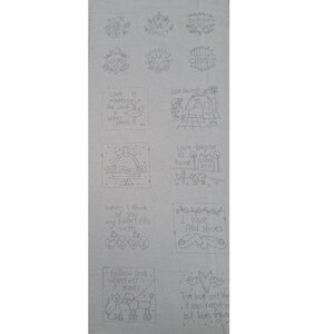 May include: A light grey fabric panel featuring a grid of twelve individual embroidery patterns in dark grey ink. Each square contains unique line art illustrations and phrases including Home, Family, Laughter, Garden, Friendship, Love, Love Makes the World a Better Place, Love Sewing, Live Laugh Love, Love Begins at Home, I Love Red Shoes, and Follow Love Wherever It Leads.