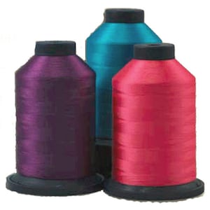 May include: Three spools of thread, one purple, one teal, and one pink.