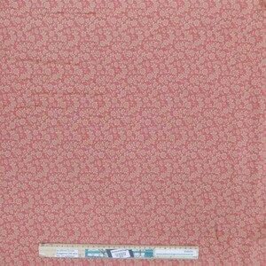 Könnte beinhalten: Nahaufnahme eines rosa Stoffes mit einem weißen Blumenmuster. Der Stoff ist strukturiert und hat einen dezenten Glanz. Der Stoff wird mit einem Lineal gemessen, auf dem "Sometimes Country" und eine Website-Adresse stehen.