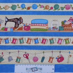 May include: A blue and cream fabric with a repeating pattern of sewing themed imagery. The pattern includes a sewing machine, spools of thread, buttons, and a thimble. The fabric is perfect for quilting, crafts, and home decor.