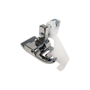 May include: A chrome sewing machine foot with a white plastic guide and a screw for adjustment. This foot is designed to help guide fabric evenly during sewing, ensuring straight seams and professional finishes.