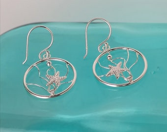 Delikatne kolczyki z drutu srebrnego w kształcie rozgwiazdy w oceanie