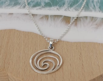 May include: A silver necklace with a circular pendant featuring a spiral design. The pendant is made of metal and has a smooth, polished finish.