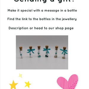 Peut inclure: Six petites bouteilles en verre avec des bouchons en li&egrave;ge et un morceau de papier roul&eacute; &agrave; l'int&eacute;rieur. Chaque bouteille est orn&eacute;e d'un ruban turquoise nou&eacute; autour du cou. Les bouteilles sont dispos&eacute;es en rang&eacute;e sur une surface blanche. Envoyer un cadeau ? Rendez-le sp&eacute;cial avec un message dans une bouteille. Trouvez le lien vers les bouteilles dans la description des bijoux ou rendez-vous sur notre page boutique.