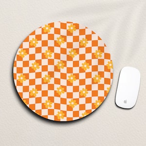 May include: A round orange and white checkered mouse mat with a pattern of yellow flowers.