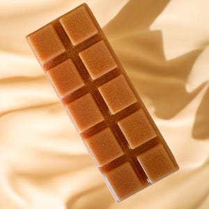 May include: A brown wax melt bar with a grid pattern. The bar is made of soy wax and has a light brown colour.