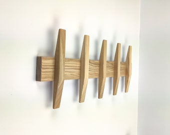 Modern wall mounted coat rack with straight hooks.