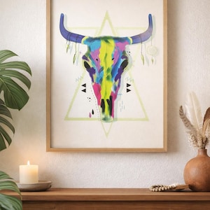 Peut inclure: Une impression d'art encadrée représentant une illustration colorée d'un crâne de taureau. Le crâne est peint avec des teintes vives de jaune, de rose, de bleu et de vert. L'œuvre comprend un triangle géométrique et des éléments décoratifs.