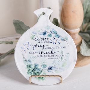 May include: White ceramic dish with a floral design and the text "rejoice always pray without ceasing give thanks in all circumstances 1 Thess 5:16-18".