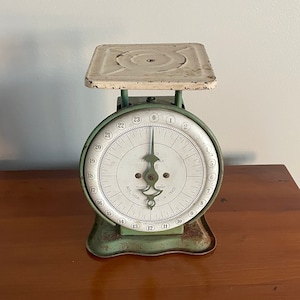 Set Of Green Kitchen Scales With Red Arrow Pointing To 150 Stock