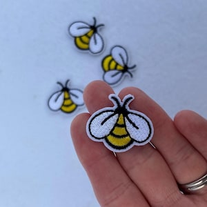 May include: Four embroidered iron-on patches of yellow and black bees with white wings.