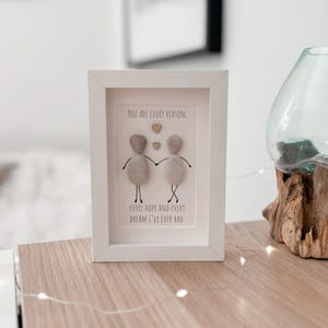 May include: White framed artwork featuring a pebble art design of two figures holding hands. The text reads "You are every reason. Every hope and every dream I've ever had."