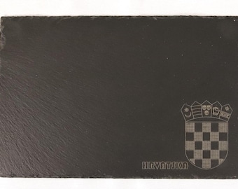 May include: A black slate serving tray with a white engraved Croatian coat of arms and the word "HRVATSKA" underneath.