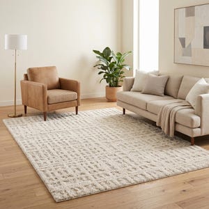 May include: A rectangular area rug featuring a high-pile, cream-coloured surface with a repeating geometric grid pattern in a slightly darker shade. The rug has a textured, shaggy appearance and covers a large portion of the light-coloured wooden floor.