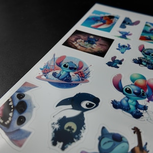 May include: A sheet of stickers featuring the character Stitch from the Disney movie Lilo & Stitch. The stickers depict Stitch in various poses, including surfing, holding balloons, and playing a ukulele. The stickers are in shades of blue, pink, and purple.